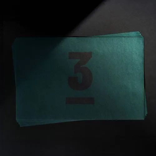 Stack of dark green placemats with a large black number 3.