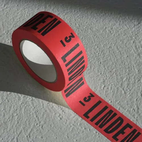 Red tape with black text '3 LINDEN' printed repeatedly, partially unrolled on a textured gray surface.